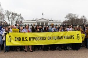 Amnesty International USA protesters hold End US hypocrisy on human rights banner at the White House