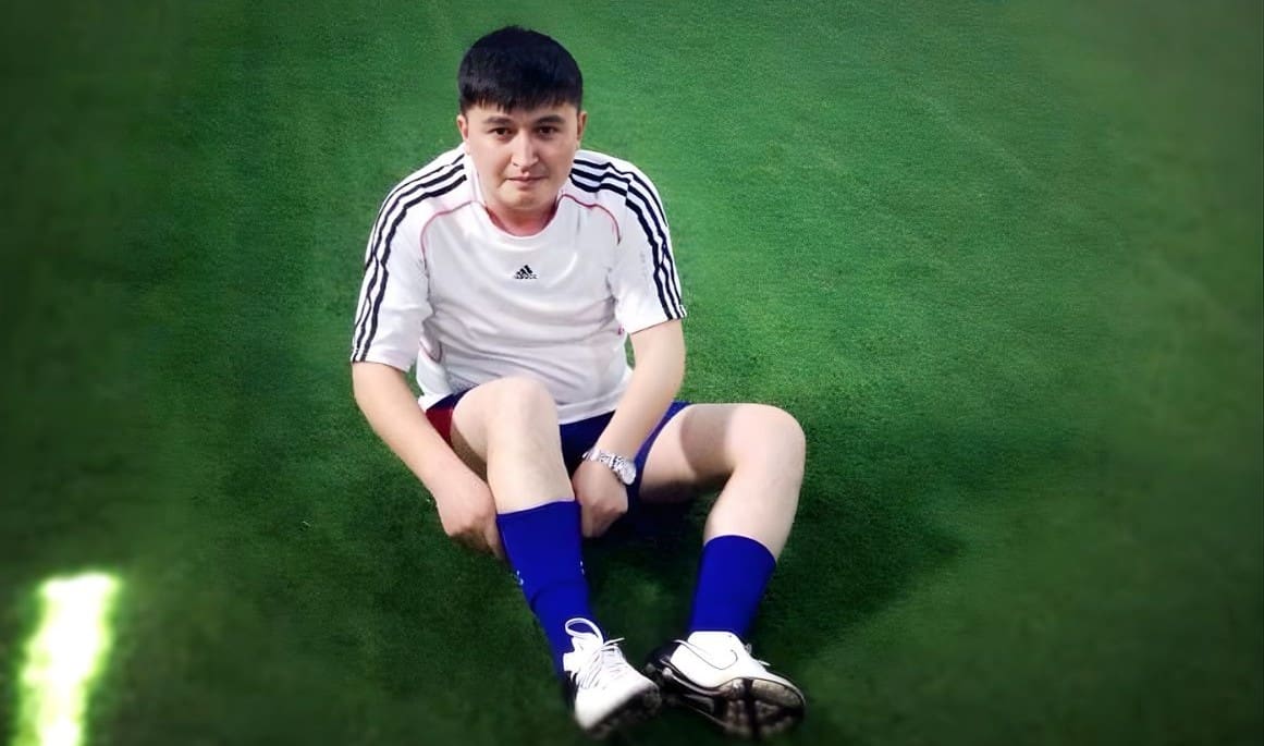 Undated photo of Ekpar Asat: he was wearing soccer sportswear seated on green turf