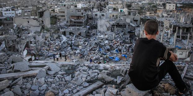 202471_a_palestinian_child_sits_above_the_ruins_of_his_ruined_home_1.jpg