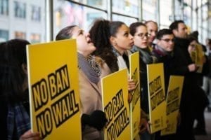 Amnesty International USA activists speak out against a ban and a wall against people