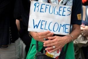 A demonstrator holds a placard reading 'Refugees welcome' during the Citizen and Solidarity March from Place de la Bastille to Place de la Republique in Paris on June 17, 2018, in support of migrants and refugees. - Some 60 people, gathered on April 30, 2018 in Ventimiglia at the French and Italian border, to start a solidarity march called by French association from Calais "L'Auberge des Migrants". This "citizens and solidarity" march of 1,400 km gathering walkers and migrants aims at symbolically connecting Ventimiglia, where migrants are blocked, to the northern French port city of Calais and then to the British capital London. The march is estimated to conclude end on July 8. (Photo by Thomas SAMSON / AFP) (Photo credit should read THOMAS SAMSON/AFP/Getty Images)