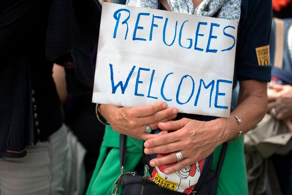 A demonstrator holds a placard reading 'Refugees welcome' during the Citizen and Solidarity March from Place de la Bastille to Place de la Republique in Paris on June 17, 2018, in support of migrants and refugees. - Some 60 people, gathered on April 30, 2018 in Ventimiglia at the French and Italian border, to start a solidarity march called by French association from Calais 