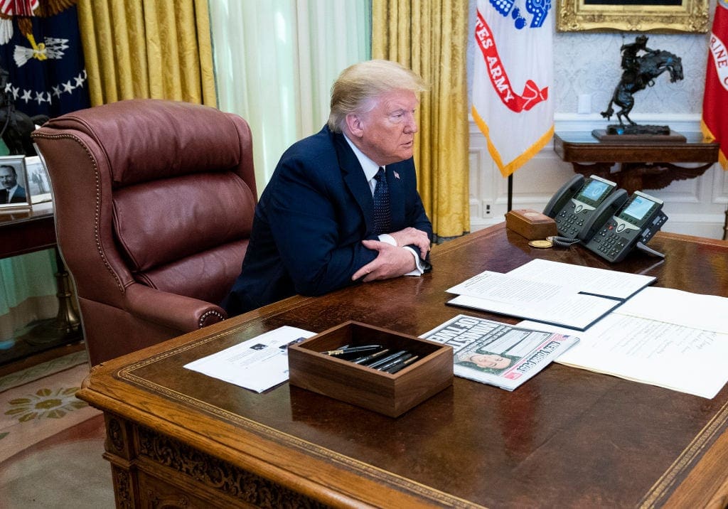 U.S. President Donald Trump, with Attorney General William Barr, speaks in the Oval Office before signing an executive order related to regulating social media