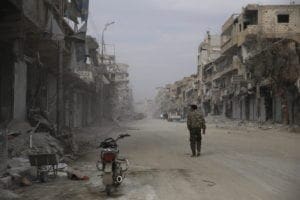 Man walks on destroyed street in Raqqa, Syria