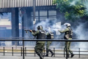 Police officers shooting tear gas