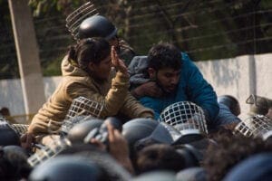 Man and woman are grabbed at all sides by police