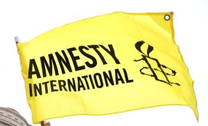 amnesty international flag, yellow with black writing