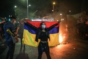 Protestor holds Colombian flag up