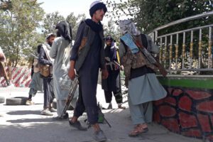 Taliban fighters stand along the roadside