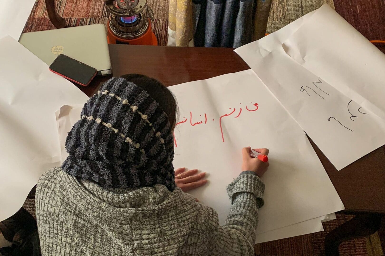 In this picture taken on January 15, 2022, an Afghan woman writes placards ahead of a women's rights protest march, in Kabul. - When the Taliban first ruled Afghanistan between 1996 and 2001, they became notorious for human rights abuses, with women mostly confined to their homes. Now back in government and despite promising softer rule, they are cracking down on women's freedoms once again. - TO GO WITH Afghanistan-Taliban-women,FOCUS by Rouba EL HUSSEINI (Photo by Rouba EL HUSSEINI / AFP) / TO GO WITH Afghanistan-Taliban-women,FOCUS by Rouba EL HUSSEINI (Photo by ROUBA EL HUSSEINI/AFP via Getty Images)