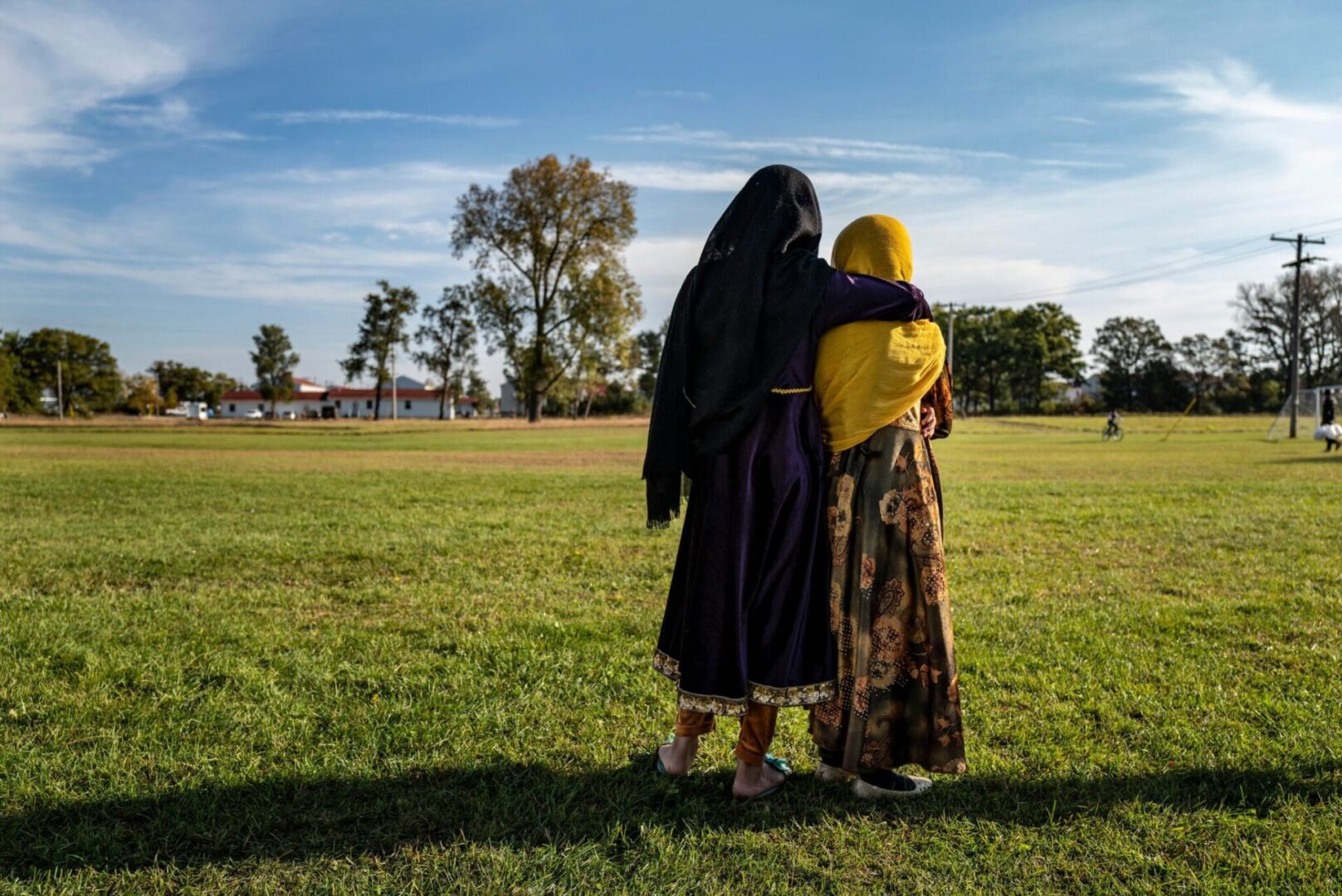 two Afghan girls watch soccer game