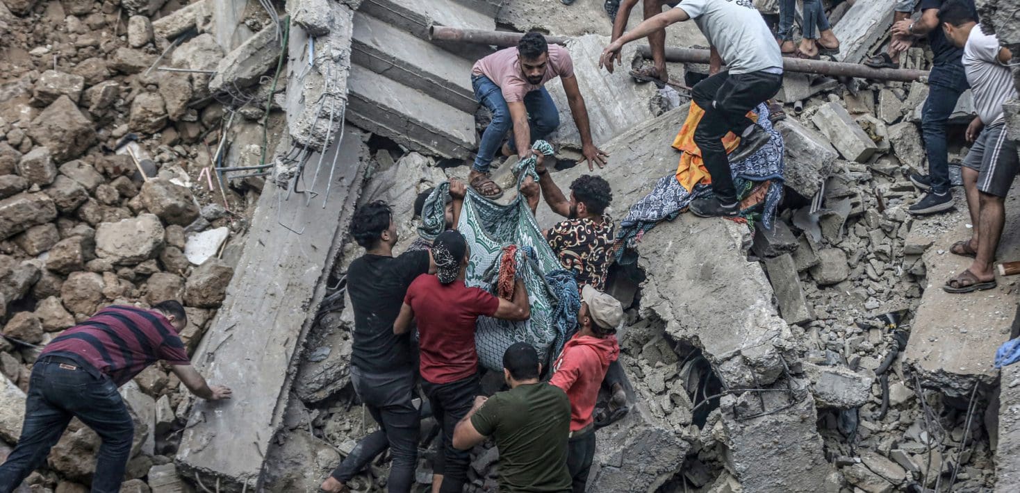 Gazans pull body in sheet from rubble