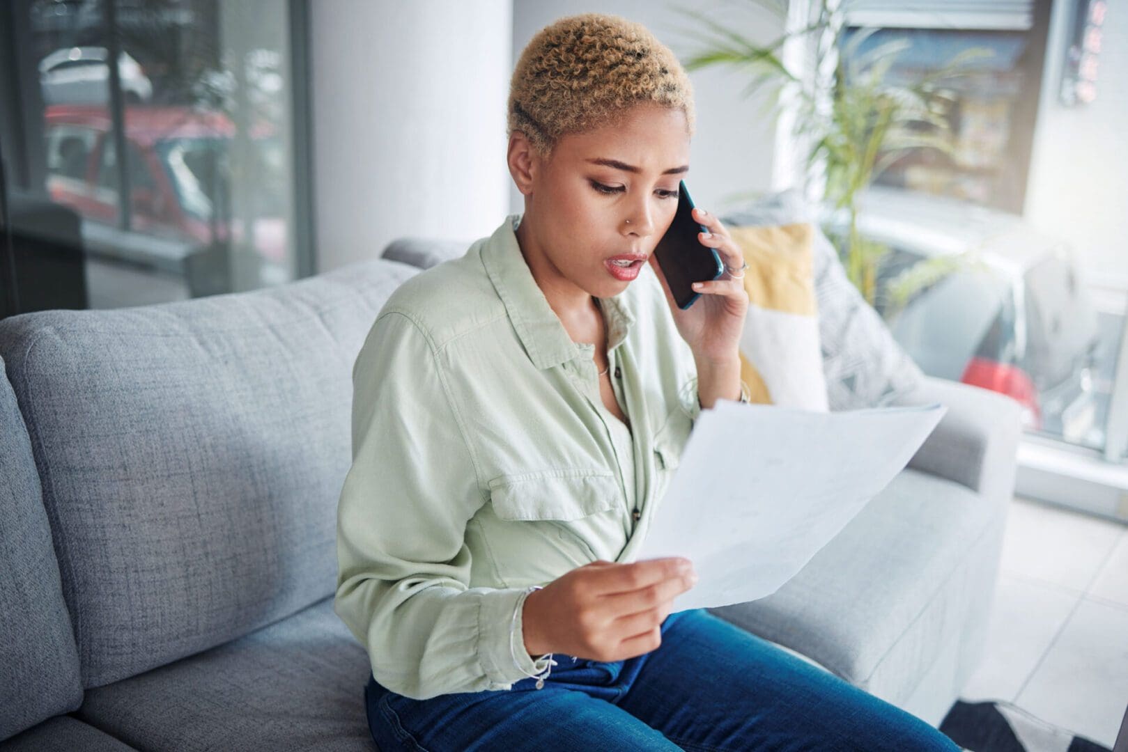 woman on the phone looking at papers (Jacob Wackerhausen/iStock)