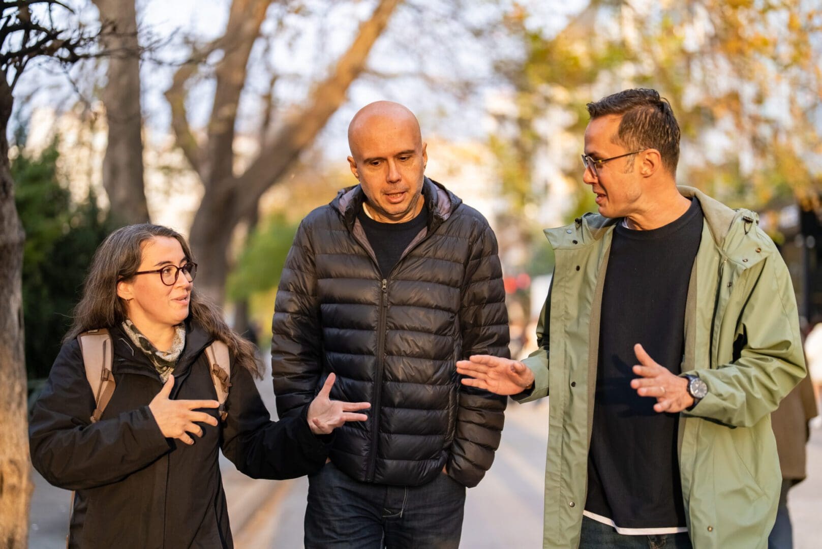 One woman and two men walking together on street