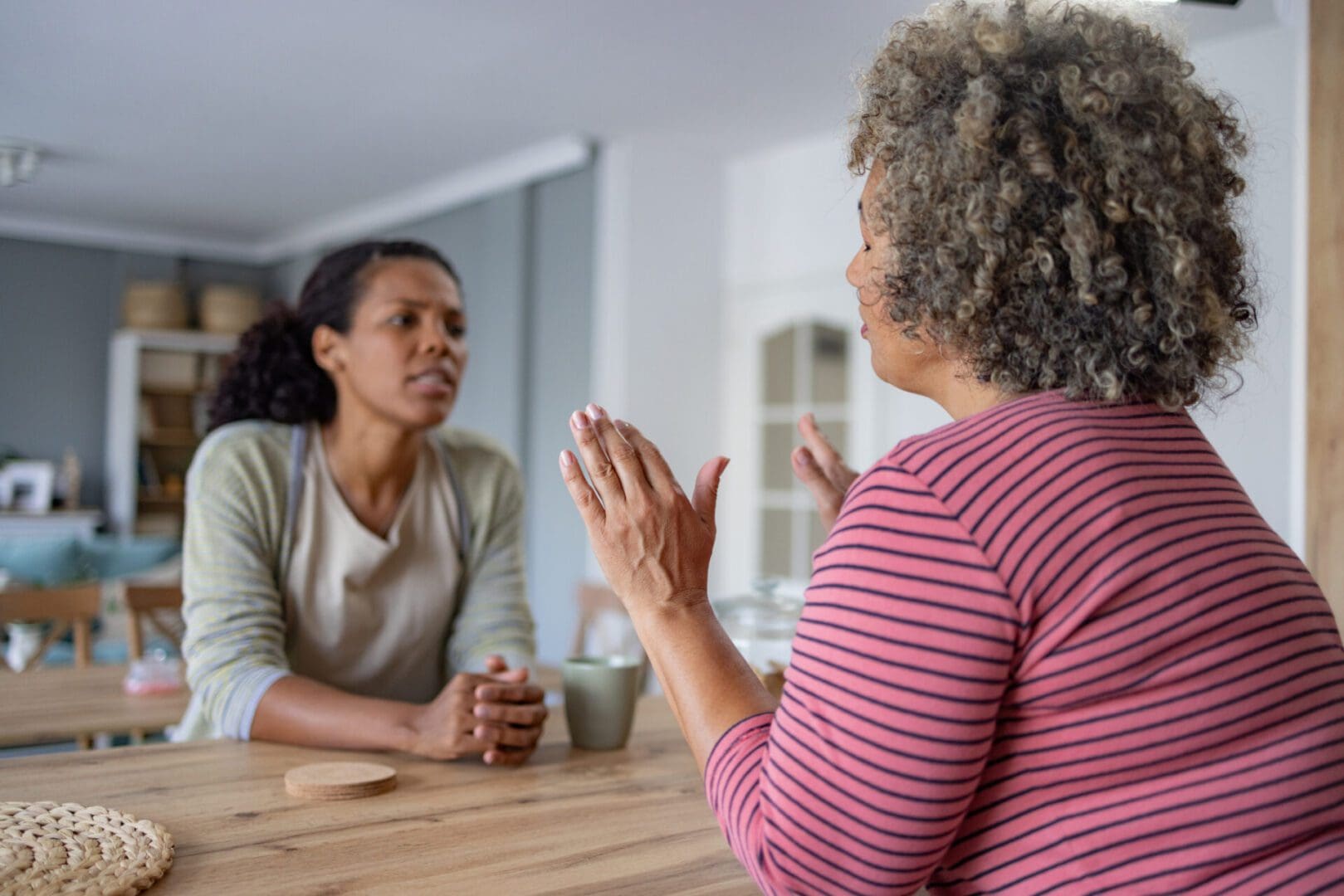 Sad woman refusing her friend's help during their conversation at home.