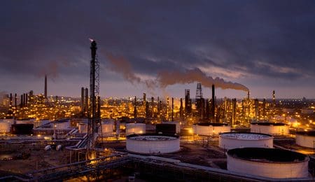 Tanks and towers of chemical refinery along Houston Ship Channel at sunrise.