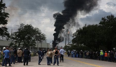 Evacuated ExxonMobil workers take a break or watch the fire from the Baytown Olefins Plant entrance on Wednesday, July 31, in Baytown. (Photo by Yi-Chin Lee/Houston Chronicle via Getty Images)