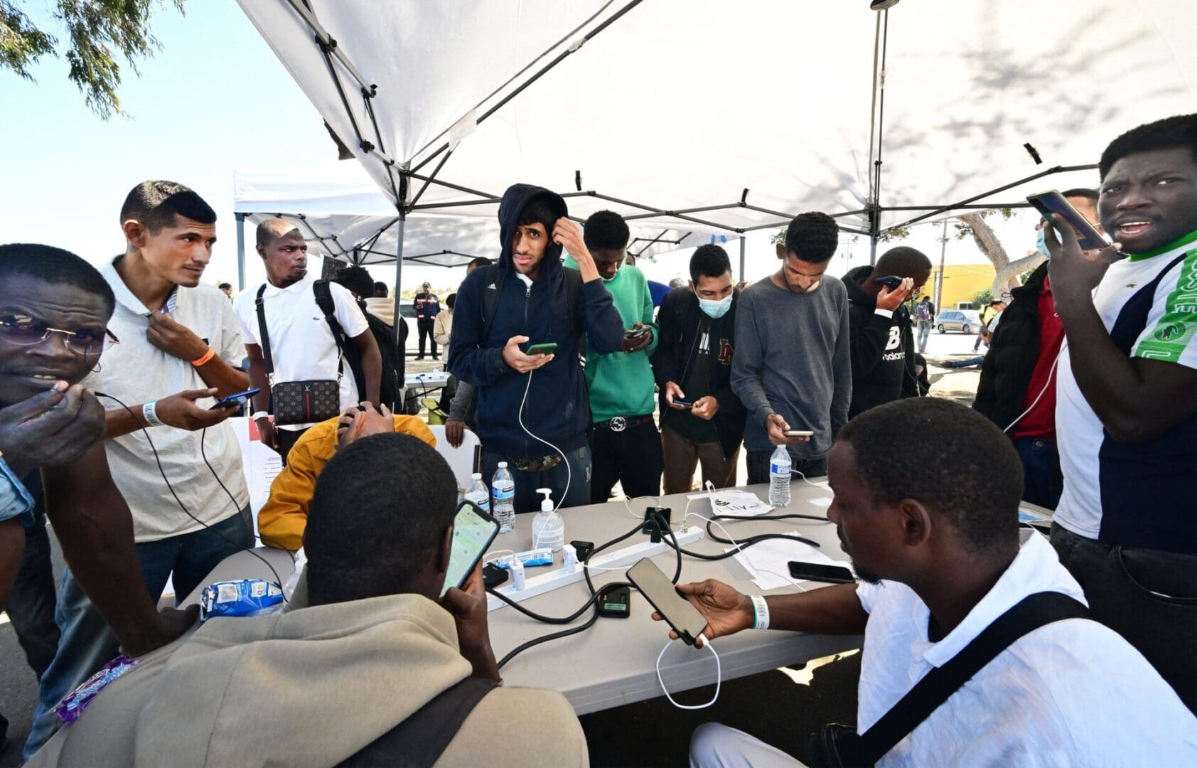 Migrants from Texas use power for their cellphones after being dropped off at a train station in San Diego, California on October 10, 2023. More than 200,000 migrants have crossed the San Diego sector of the US-Mexico border this year from January to August, the highest number in two decades. (Photo by Frederic J. BROWN / AFP) (Photo by FREDERIC J. BROWN/AFP via Getty Images)