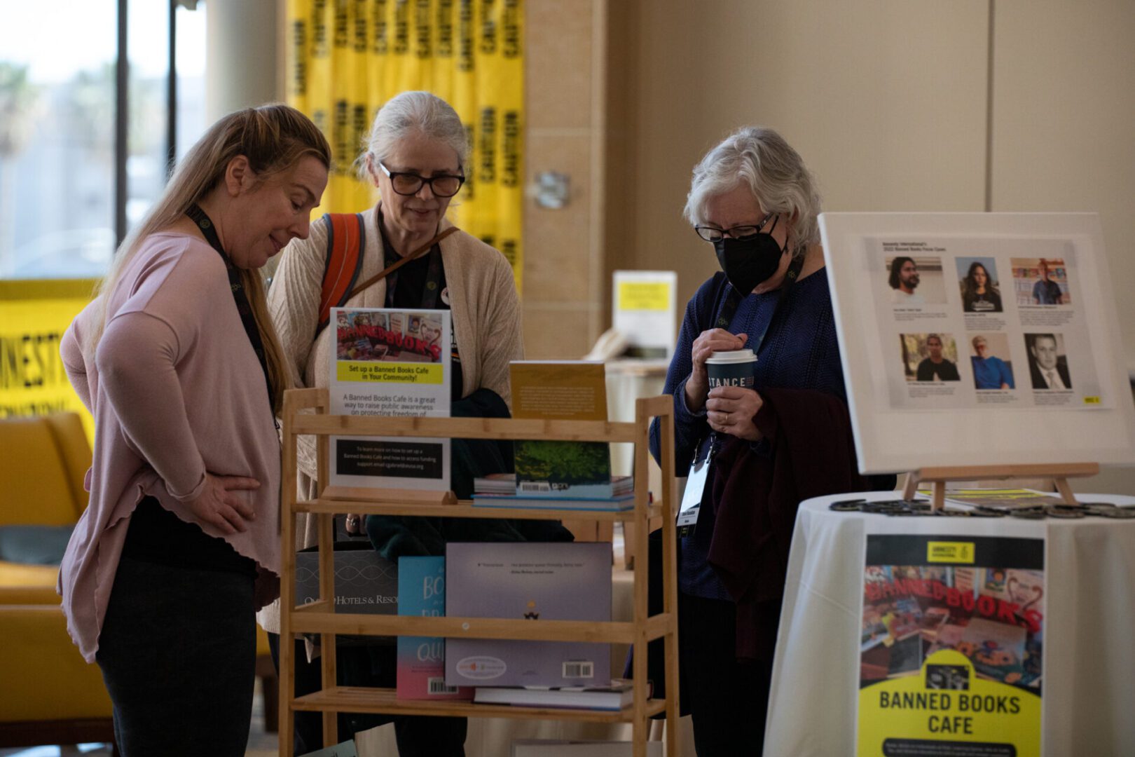 Amnesty International Annual General Meeting three women look at display of books