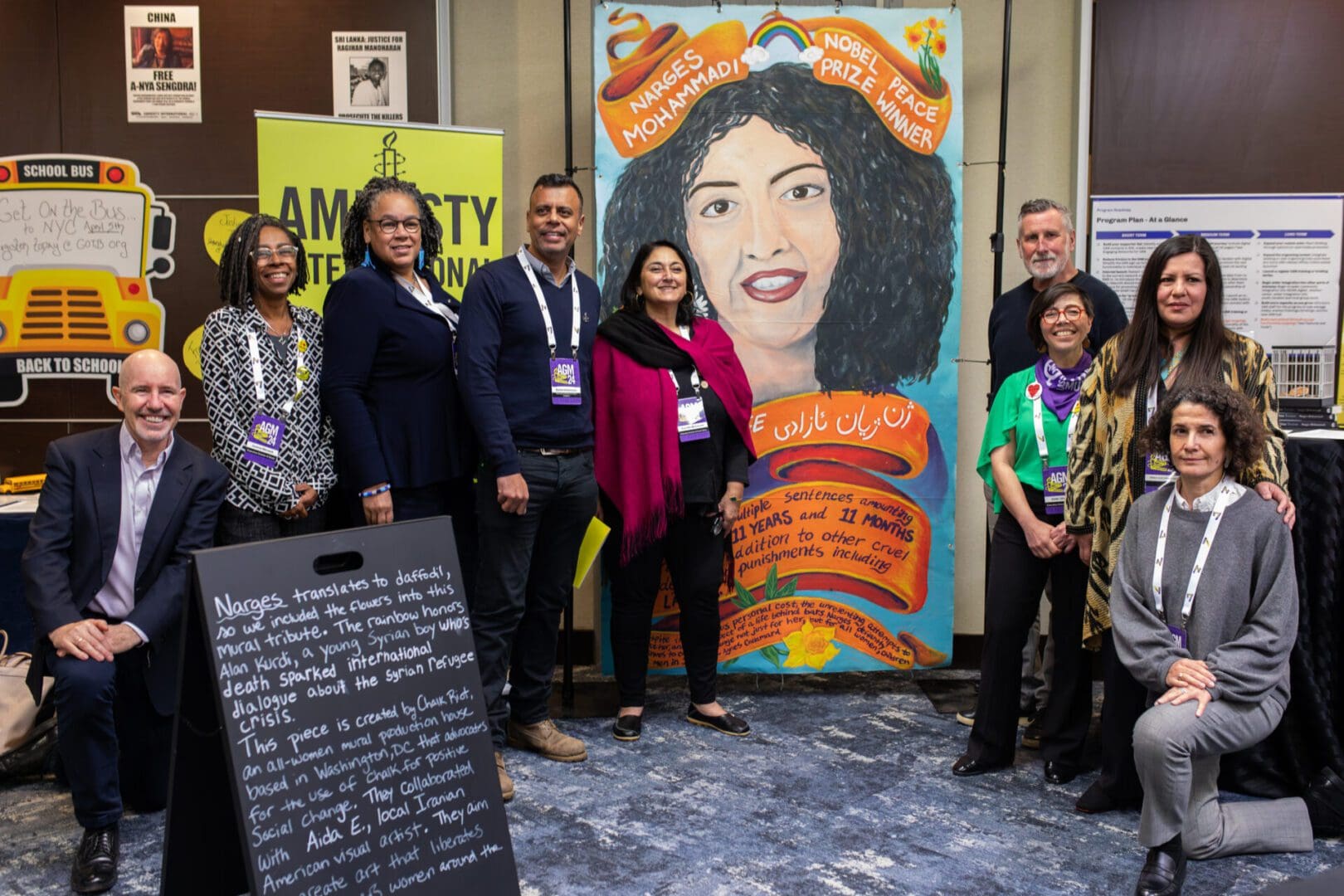 Section Directors and Erika Guevera-Rosas (Senior Director of Global Research, Advocacy and Policy, International Secretariat) stand with mural of Nobel Peace Prize winner Narges Mohammadi, who has been imprisoned in Iran since 2021 for her human rights activism. (Lauren Murphy/Amnesty International)