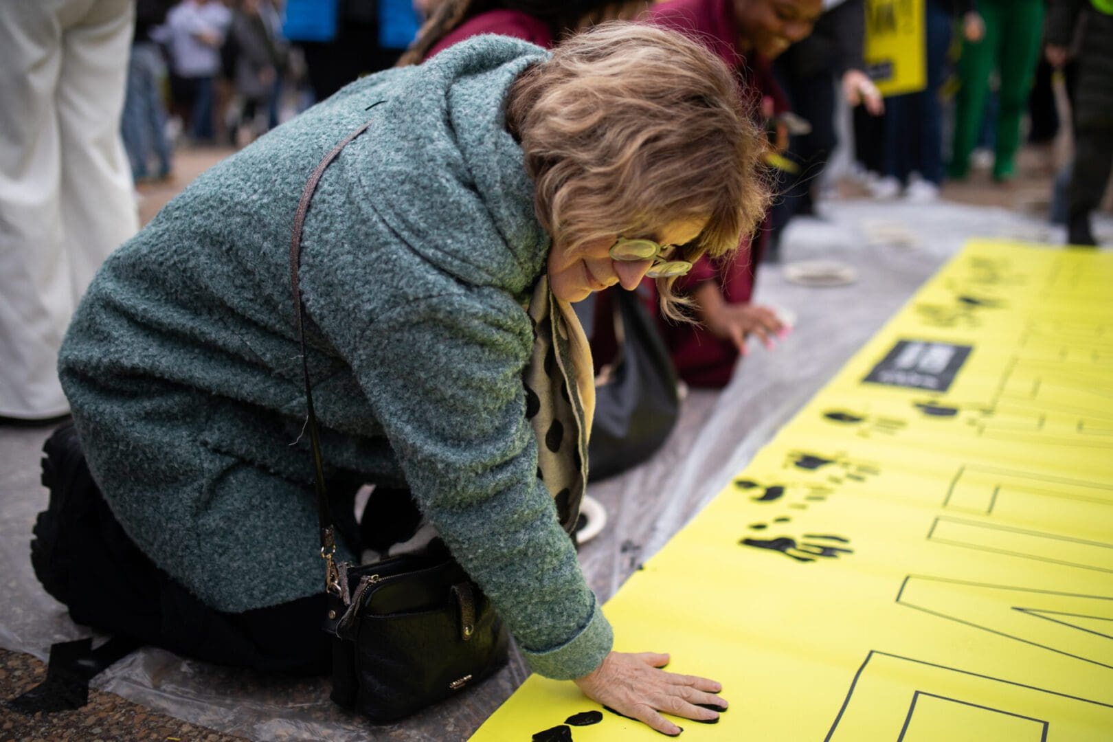 Secretary General Agnès Callamard adds her handprint to a collective sign that reads “Let Gaza Live.”