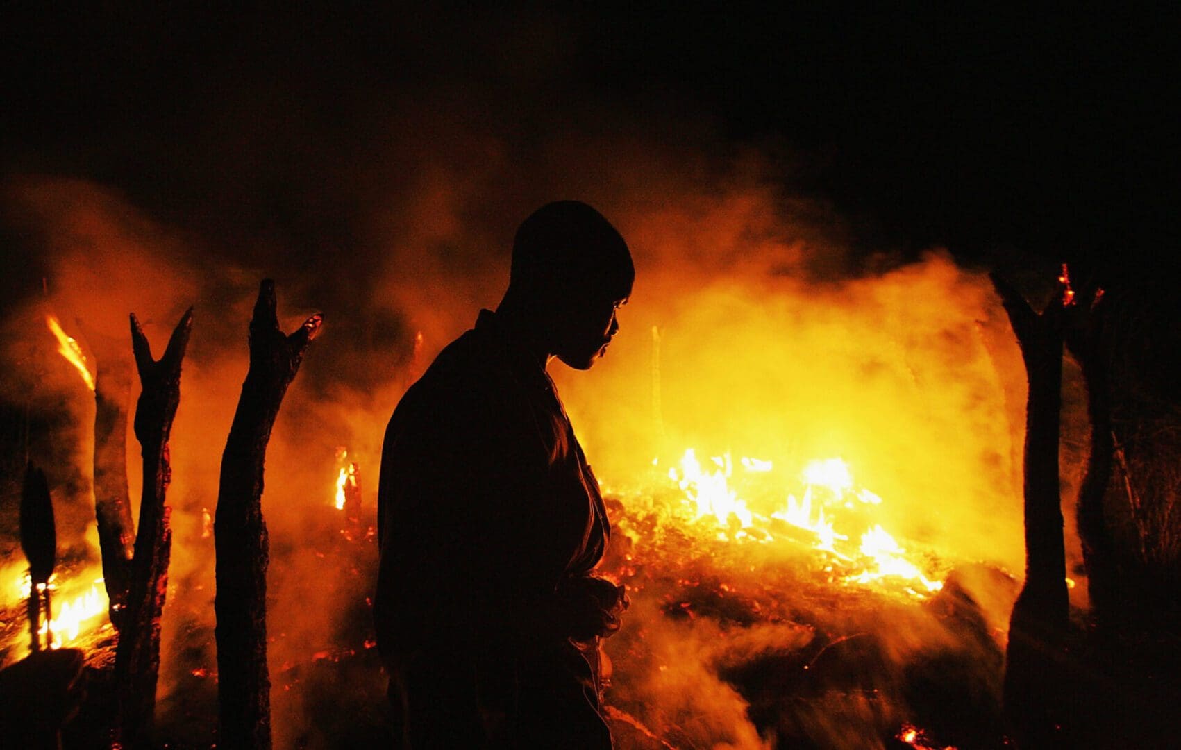 CHERO KASI, SUDAN - SEPTEMBER 7: A Sudanese rebel fighter from the Justice and Equality Movement (JEM) sombrely watches the abandoned village of Chero Kasi burn less than an hour after Janjaweed militiamen set it ablaze in the violence plagued Darfur region September 7, 2004. United States Secretary of State Colin Powell told a U.S. congressional committee this week that the ethnic violence in Sudan amounts to 