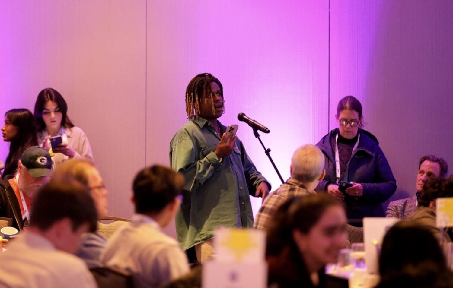 Young man speaking in a mic in a conference hall