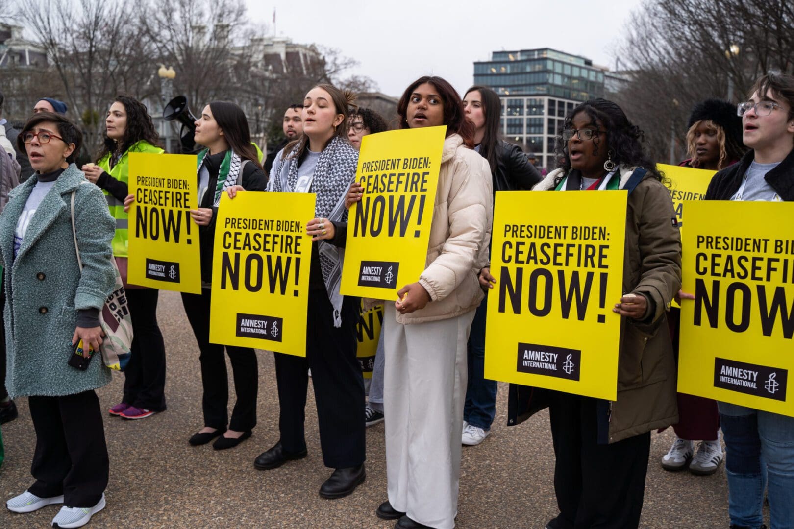 Amnesty International USA protesters hold Ceasefire Now signs