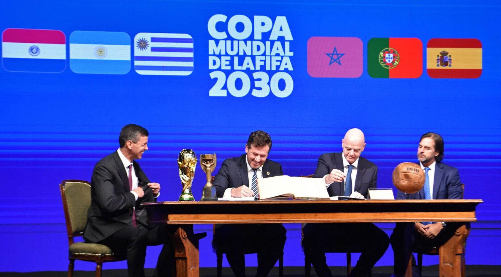 Conmebol's President Alejandro Dominguez (L-2) and FIFA President Gianni Infantino (R-2), accompanied by Paraguay's President Santiago Peña (L) and Uruguay's President Luis Lacalle(R), sign a book of minutes of the 2030 World Cup during Conmebol's 78th Ordinary Congress in Luque, Paraguay on April 11, 2024. (Photo by NORBERTO DUARTE / AFP) (Photo by NORBERTO DUARTE/AFP via Getty Images)