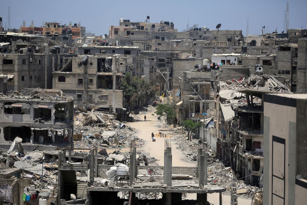 Palestinians walk along a devastated street in Khan Yunis in the southern Gaza Strip on June 14, 2024, amid the ongoing conflict between Israel and the Palestinian Hamas militant group. (Photo by Eyad BABA / AFP) (Photo by EYAD BABA/AFP via Getty Images)