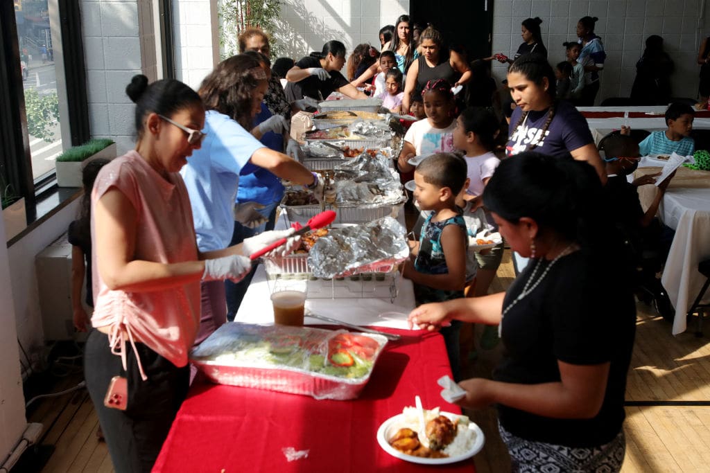 People attend a dinner for asylum seeker families at Romemu Center in New York City on June 27, 2023. The unprecedented arrival of 80,000 asylum seekers since spring 2022 has put pressure on the capacity of the megacity, where dozens of hotels have been transformed into emergency accommodation centers. It has also presented a challenge for the New York public school system, which is the largest in the United States with one million students. Located in a predominantly Hispanic neighborhood on Manhattan's Upper West Side, the PS145 school seemed ready to deal with it, with its bilingual Anglo-Spanish and Anglo-Russian educational programs, likely to accommodate children from families fleeing the war in Ukraine. (Photo by Leonardo Munoz / AFP) (Photo by LEONARDO MUNOZ/AFP via Getty Images)
