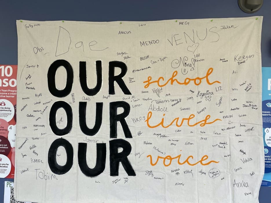 AIUSA Washtenaw International High School group signed banner our school, our lives, our voice
