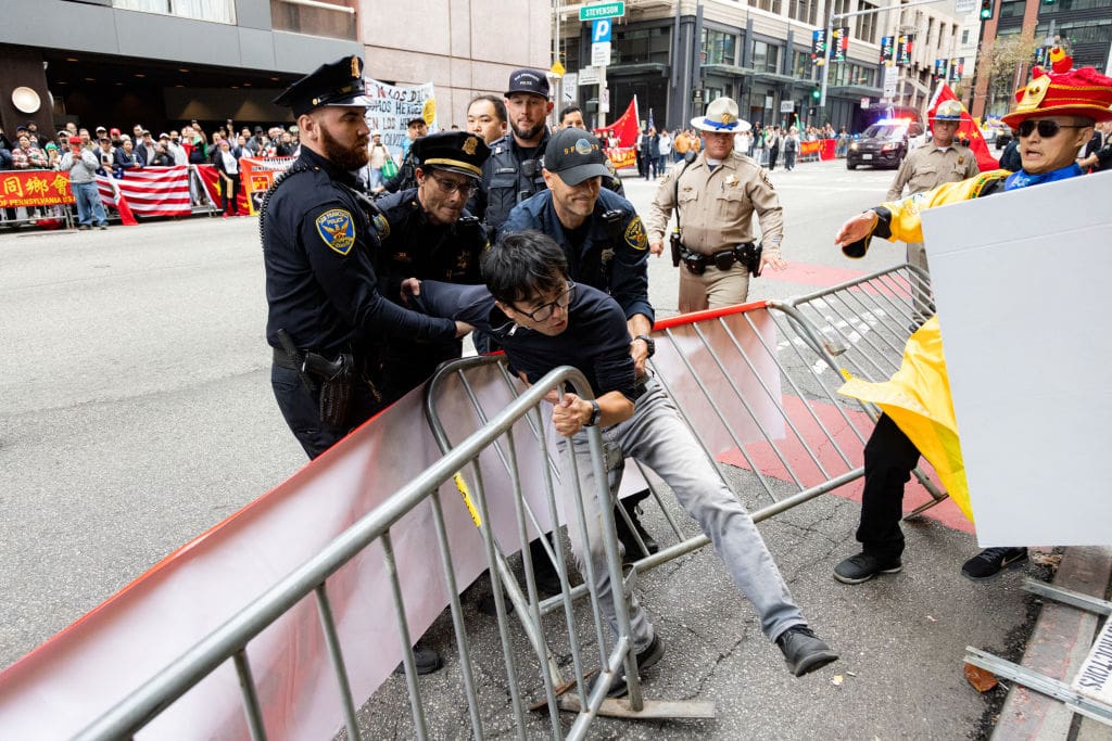 Police try to detain a man after skirmishes between anti-Chinese Communist Party protesters and pro-China protesters near the Asia-Pacific Economic Cooperation (APEC) summit in San Francisco, on November 16, 2023. The APEC Summit takes place through November 17. (Photo by Jason Henry / AFP) (Photo by JASON HENRY/AFP via Getty Images)