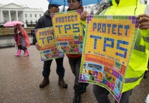 people holding signed with protect TPS