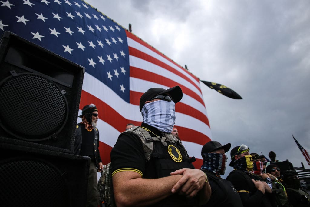 PORTLAND, OREGON, UNITED STATES - 2020/09/26: A member of the Proud Boys guards the front stage as another member of the proud boys gives a speech during the rally. Hundreds of members of the far-right group Proud Boys arrived at Delta Park in Portland, Oregon for a rally that expected high violence between Proud Boys and Antifa & BLM anti-protesters, yet the afternoon at Delta Park remained mostly peaceful. (Photo by Stanton Sharpe/SOPA Images/LightRocket via Getty Images)