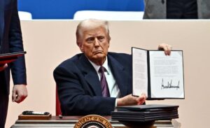 US President Donald Trump signs executive orders during the inaugural parade inside Capital One Arena, in Washington, DC, on January 20, 2025. (Photo by ANGELA WEISS / AFP) (Photo by ANGELA WEISS/AFP via Getty Images)