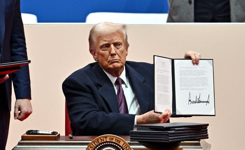 US President Donald Trump signs executive orders during the inaugural parade inside Capital One Arena, in Washington, DC, on January 20, 2025. (Photo by ANGELA WEISS / AFP) (Photo by ANGELA WEISS/AFP via Getty Images)
