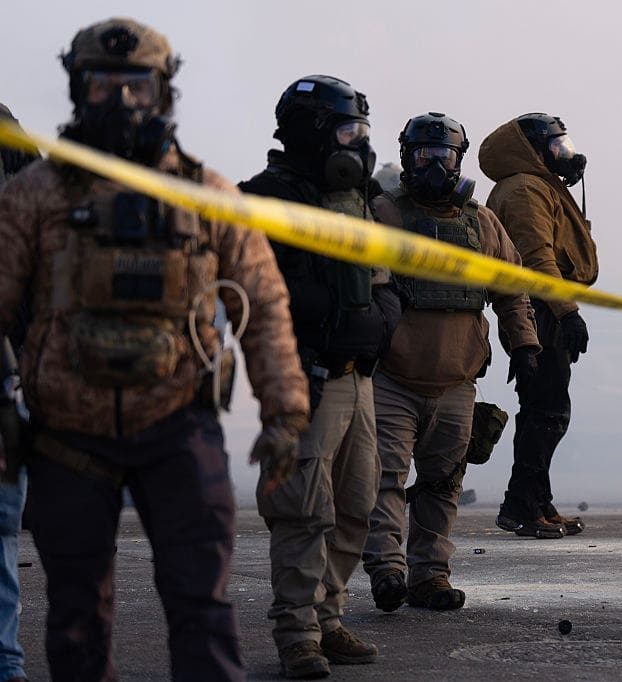 MINNEAPOLIS, MN. - JANUARY 2026: Federal agents stand in tear gas and face protesters on Nicollet Avenue