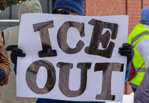 protestor holds an anti-ICE sign during a rally