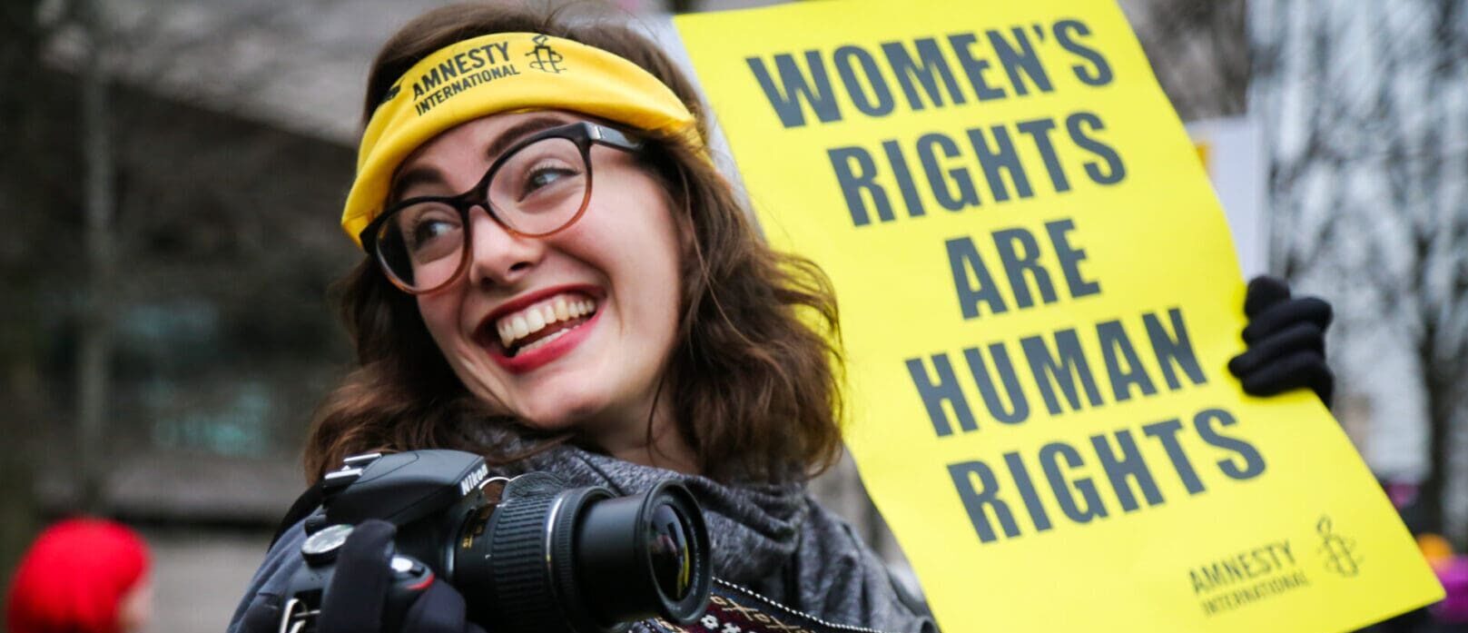 woman holding women's rights are human rights sign at protest