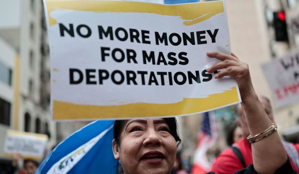 LOS ANGELES, CALIFORNIA - MARCH 01: A demonstrator carries a sign reading 'No More Money For Mass Deportations' as immigrants rights supporters march downtown during a 'March for Dignity' on March 01, 2025 in Los Angeles, California. The march was organized by faith groups along with immigrants rights organizations as a peaceful protest over the Trump administration's immigration policies. (Photo by Mario Tama/Getty Images)
