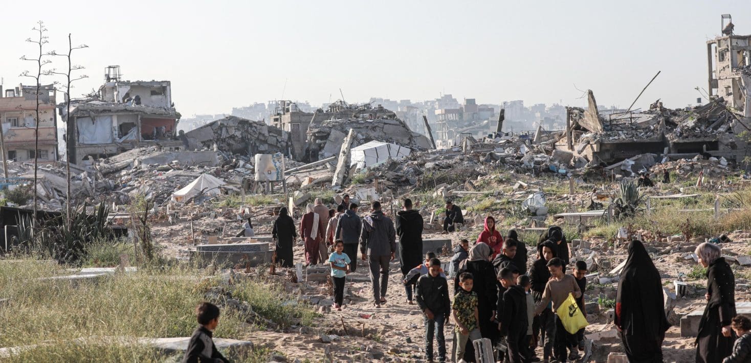 People walking through rubble in Gaza.