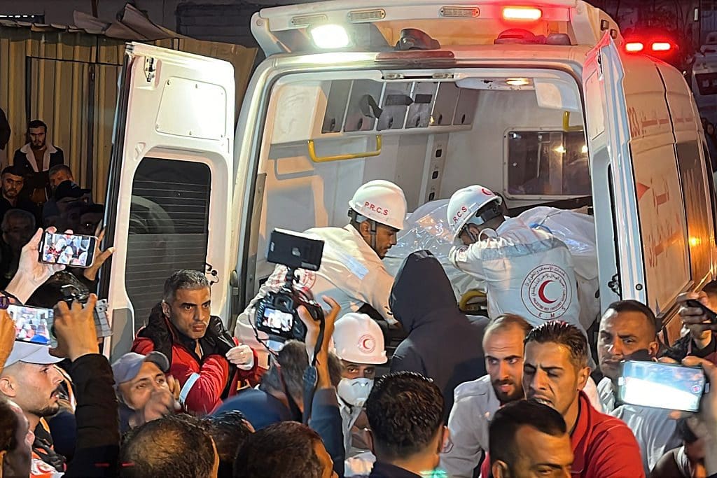 Paramedics lifts body into ambulance.