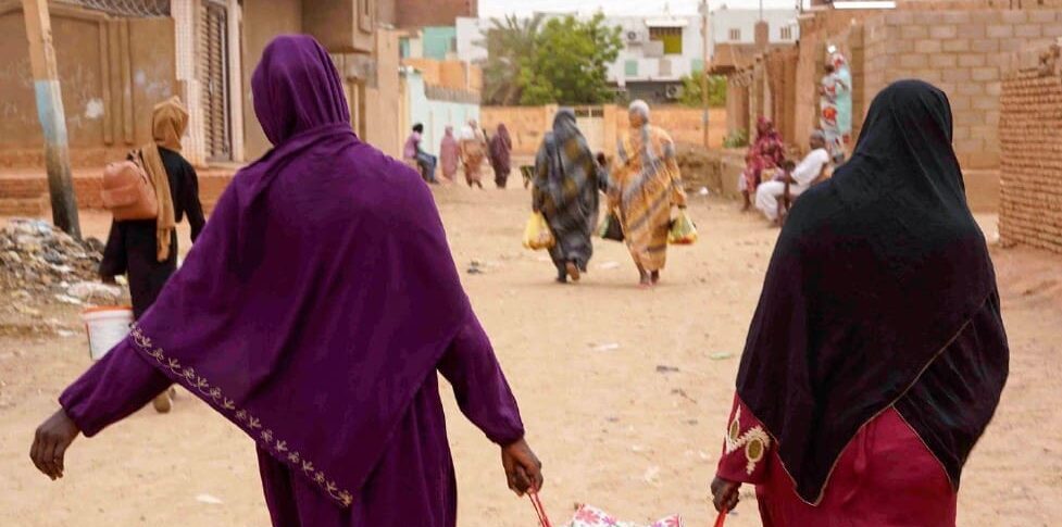 Women carrying belongings walk down a street in Omdurman, the capital's twin city in Sudan, on May 29, 2023. (Photo by -/AFP via Getty Images)