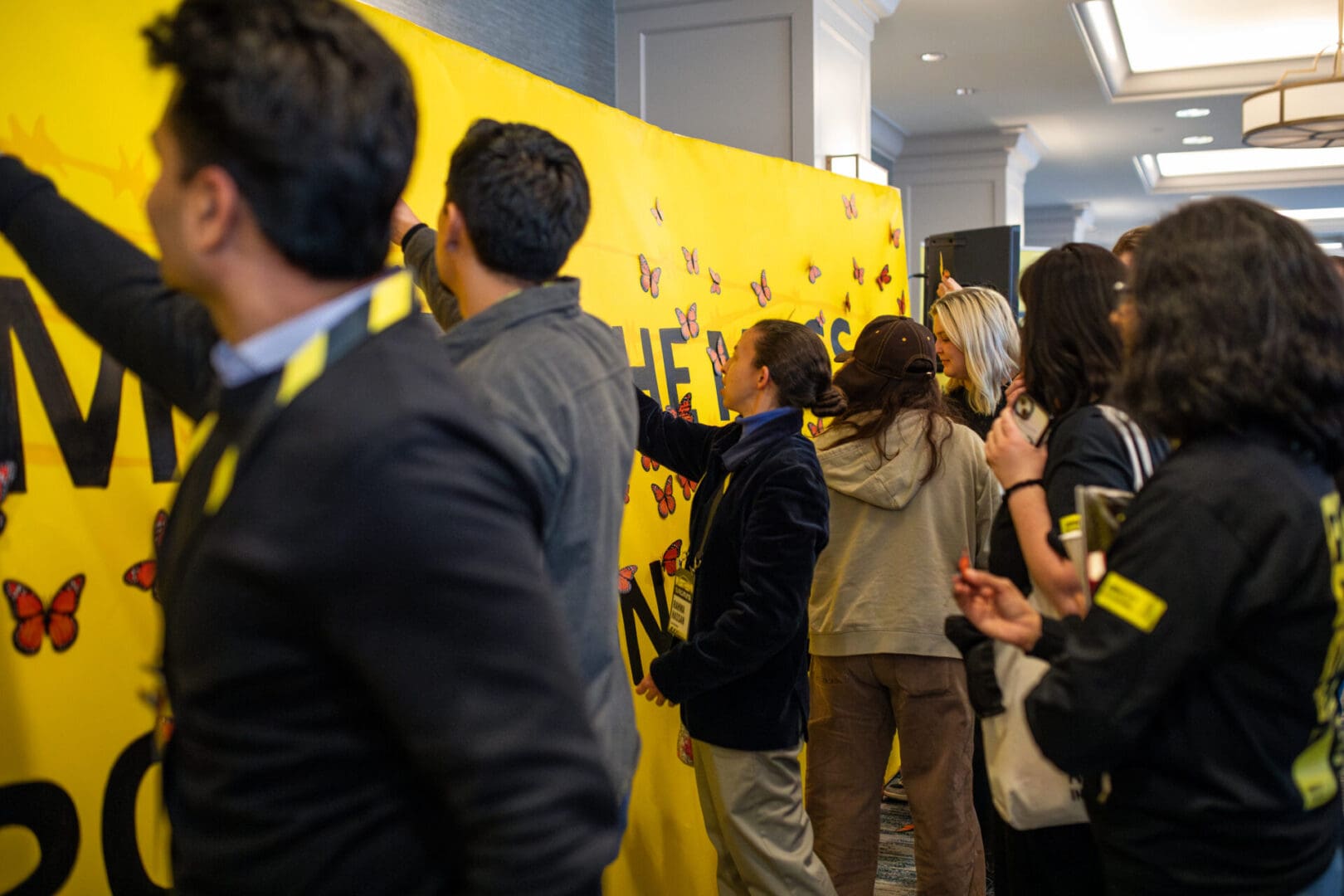 Attendees peppered the bright yellow canvas with paper butterflies, serving as a visual representation of collective advocacy and a rallying point for continued action.