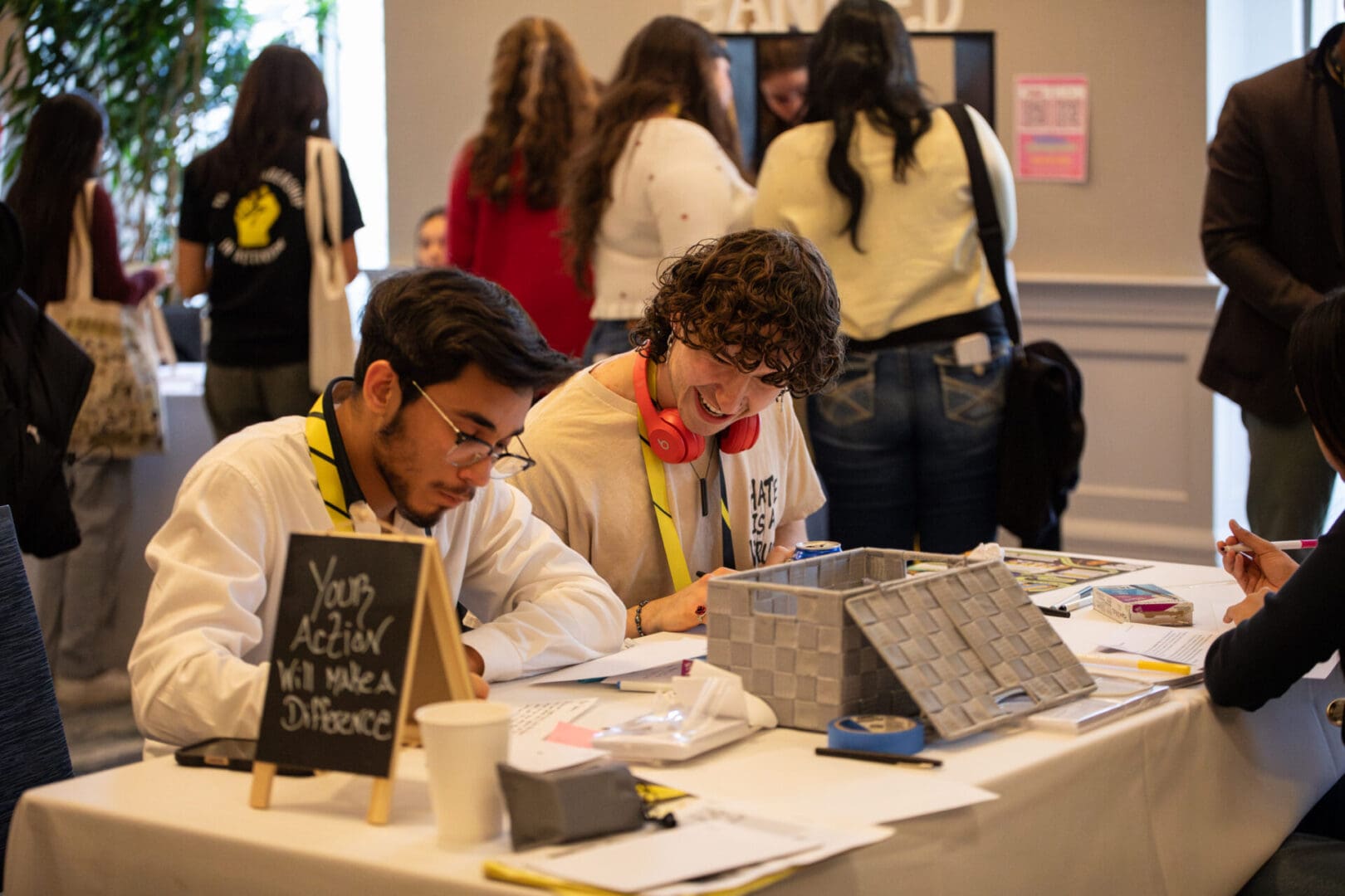 Youth attendees sharing information at Action Alley table.