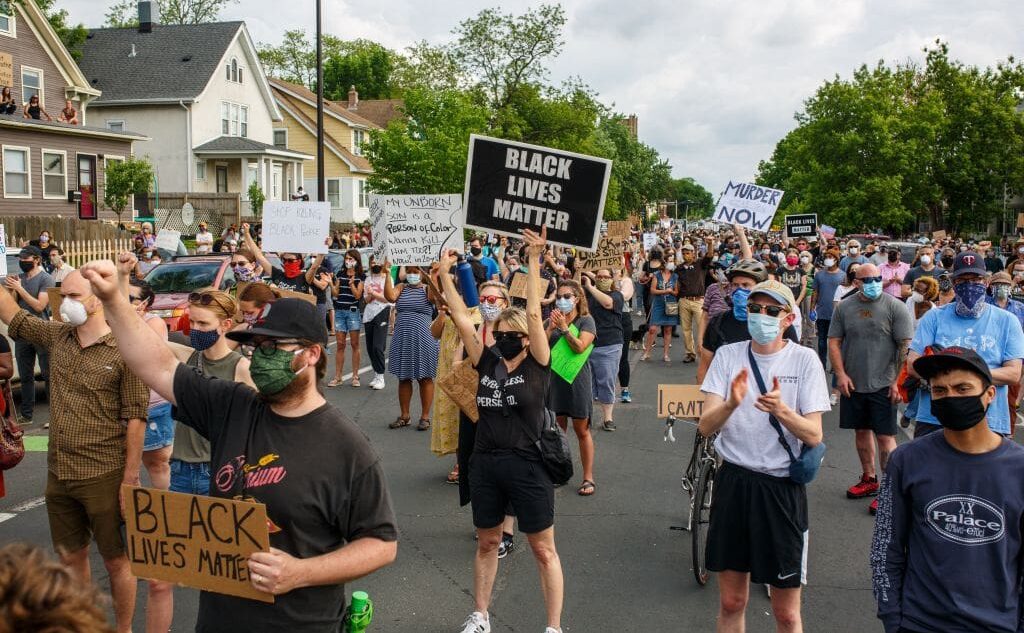 People hold signs and protest after a Minneapolis Police Department officer allegedly killed George Floyd, on May 26, 2020 in Minneapolis, Minnesota.