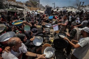 Crowds form as Palestinians, including children, line up in Gaza City to receive food distributed by a charity amid ongoing Israeli blockade and attacks on Gaza