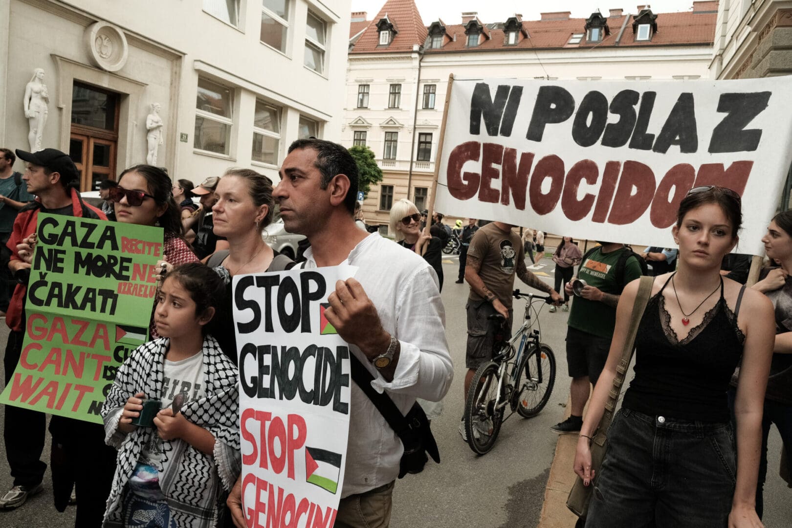 Protesters with forlorn looks on their faces hold signs that say 