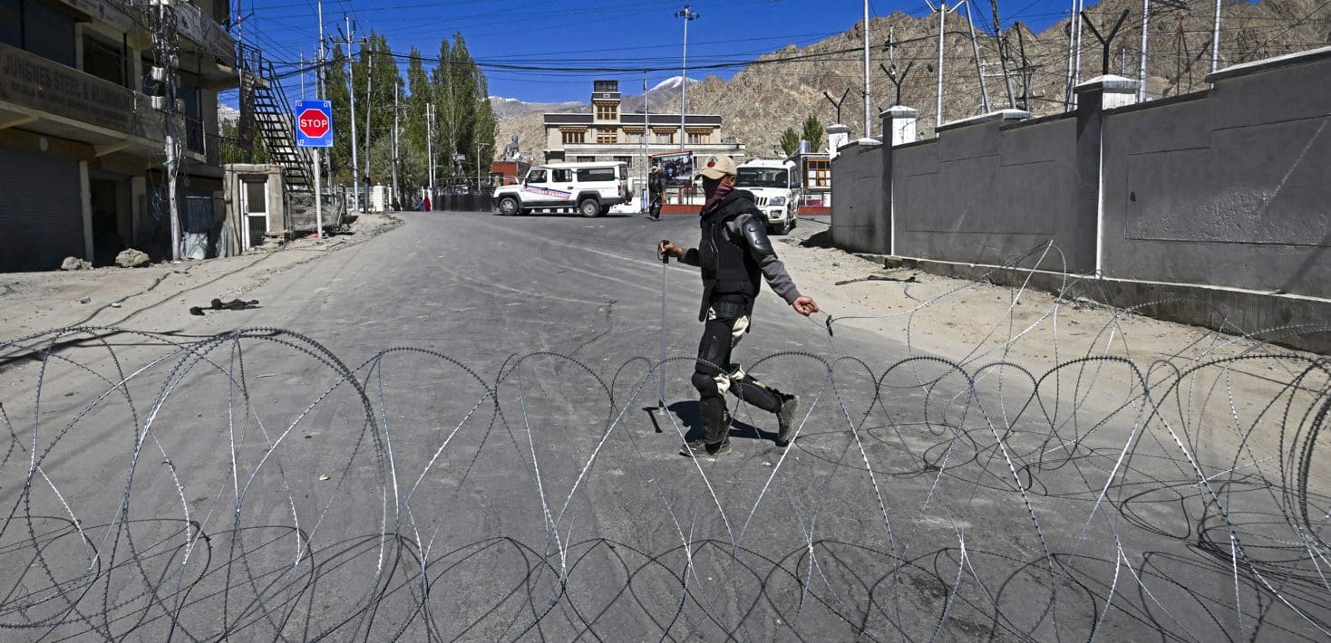 person walking in street, barbed wire